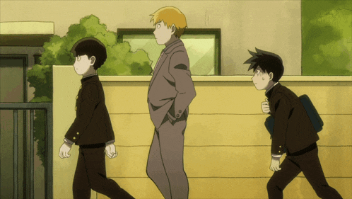 a man in a suit stands next to two boys in school uniforms