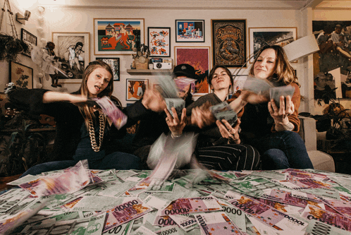 a group of people are sitting on a table with a pile of money that says 100000