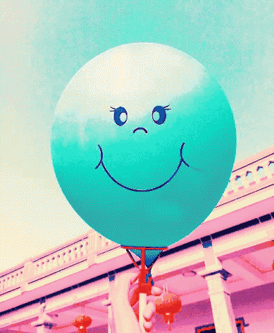 a person is holding a blue balloon with a smiley face on it and the word sengummu written above it