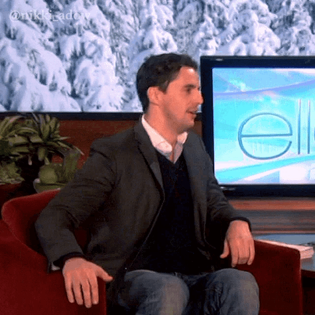 a man in a suit is sitting in front of a television with the word ellen on it