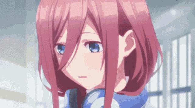 a close up of a pink haired anime girl with blue eyes and headphones .