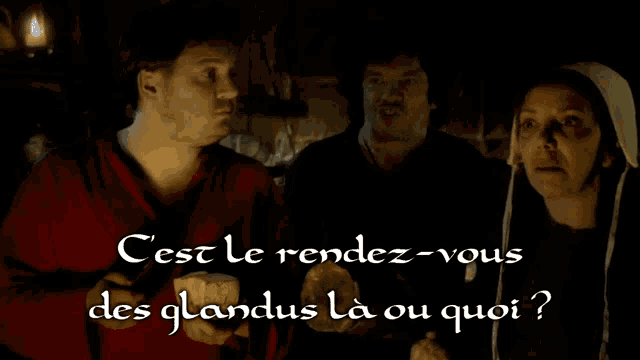 two men and a woman are standing in a dark room with the words cest le rendez-vous des glandus la ou qui