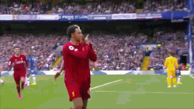a soccer player in a red jersey giving a thumbs up