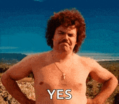 a shirtless man with a mustache is standing with his hands on his hips and the word yes on his chest .