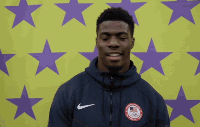 a man wearing a nike jacket with the united states olympic team logo on it