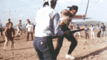 a blurry picture of a man holding a sword in front of a crowd of people