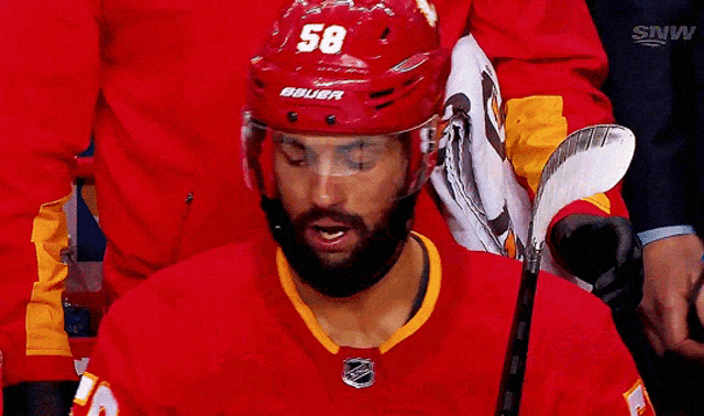 a hockey player wearing a helmet with the number 58 on it