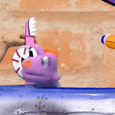 a person is brushing a stuffed animal 's teeth with a pink brush