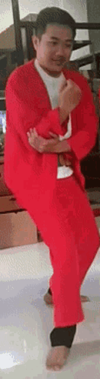 a man in a red outfit is standing on one leg
