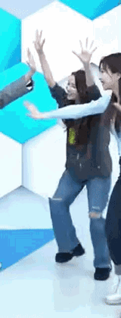 a group of women are dancing together with their arms in the air .