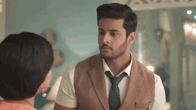 a man in a suit and tie is looking at a woman