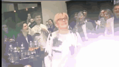a group of people are gathered around a woman wearing glasses and a shirt that says " more people "