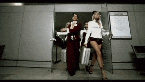 a group of women carrying suitcases are walking through an airport doorway