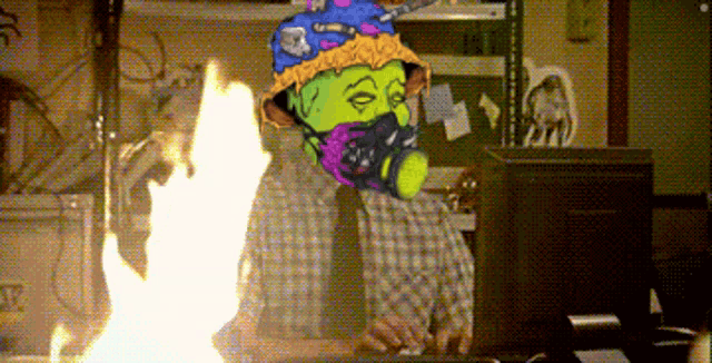 a man wearing a gas mask stands in front of a large fire