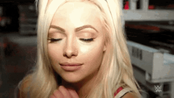 a close up of a woman 's face with a wrestling logo in the corner
