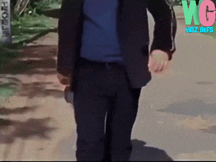a man in a suit is walking down a path with wg biz gif written on the bottom right