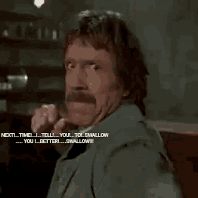 a man with a beard and mustache is making a funny face while talking to another man .