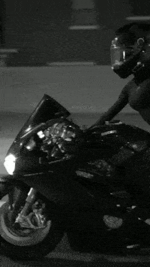 a woman wearing a helmet sits on a motorcycle that says ducati on it