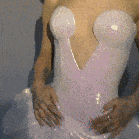 a woman is wearing a white dress with a v-neck and a plunging neckline .