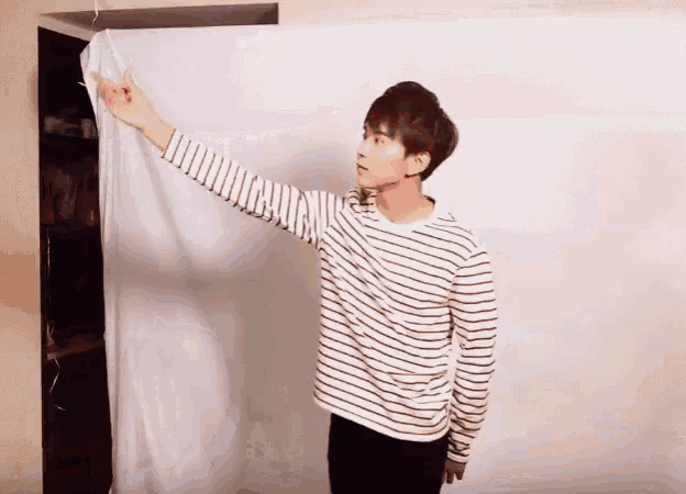 a man in a striped shirt is holding a white cloth in his hand