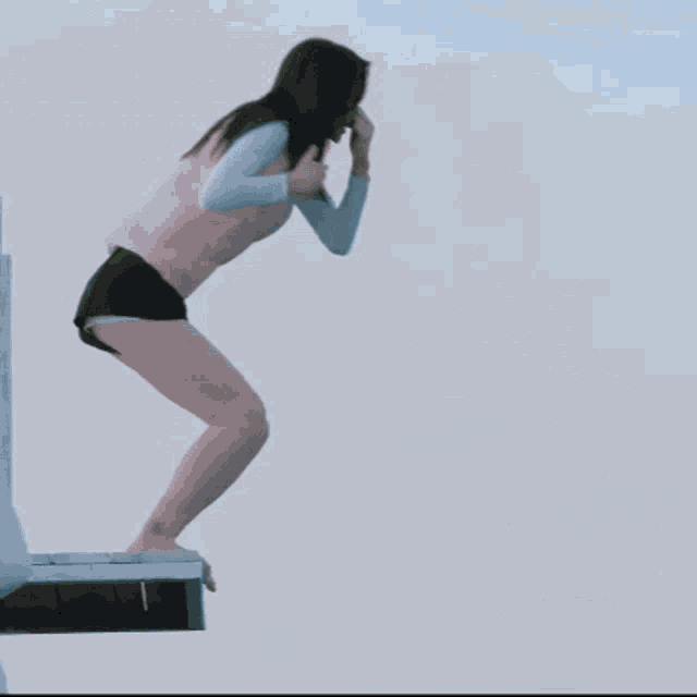a person jumping off a diving board into the water