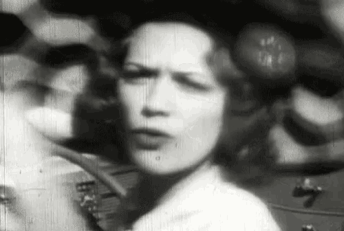 a woman 's face is shown in a black and white photo with a blurred background