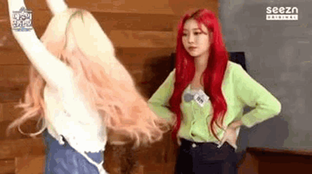 two girls with red hair are standing next to each other .