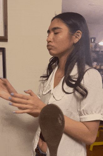 a woman in a white shirt is making a face