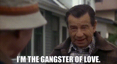 a man in a plaid shirt is smiling and says `` i 'm the gangster of love '' .