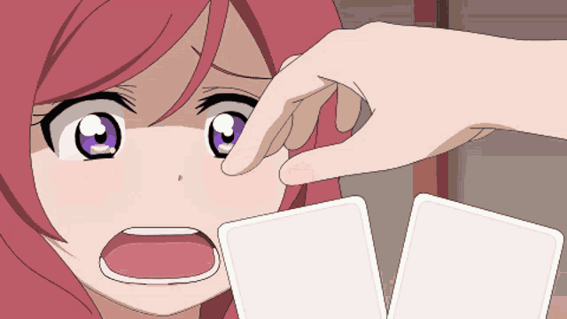 a cartoon girl with red hair and purple eyes is being touched by someone 's hand