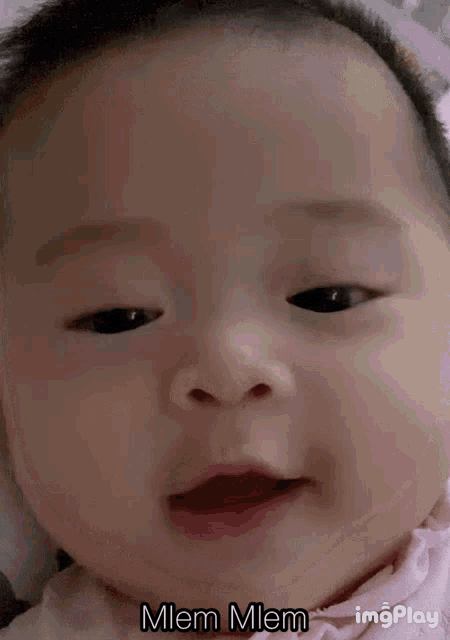 a close up of a baby 's face with the words mlem mlem above it