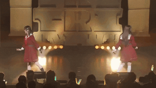 two girls are dancing on stage in front of a sign that says t-r-r-i