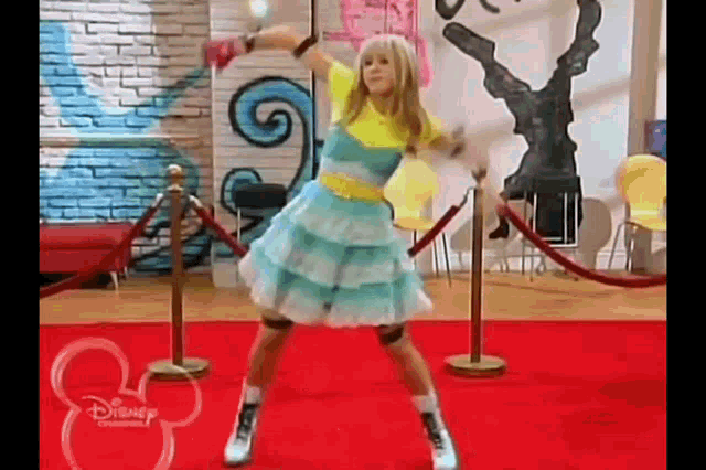 a girl is dancing on a red carpet in a room .