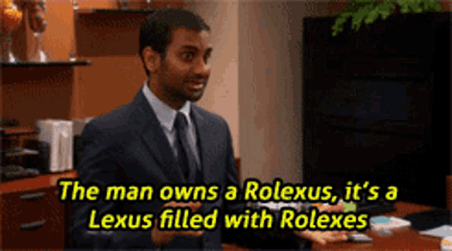 a man in a suit and tie says the man owns a rolex