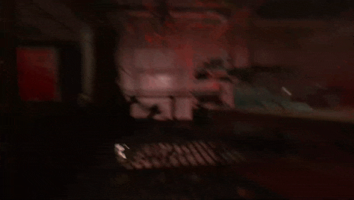 a blurry picture of a dark room with a red light coming out of a window .