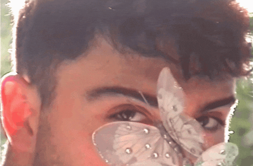 a close up of a man 's face with a butterfly on it