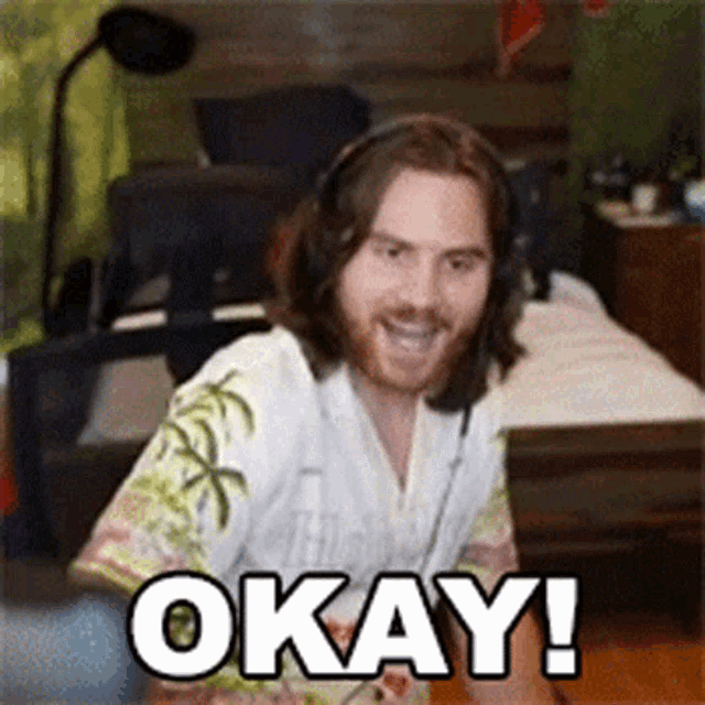 a man wearing headphones and a shirt that says okay is smiling