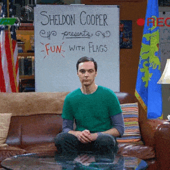 sheldon cooper is sitting on a couch in front of a whiteboard that says fun with flags