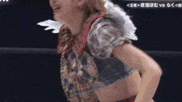 a blurry picture of a woman in a wrestling ring with japanese writing on the bottom
