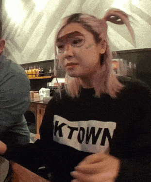 a woman wearing a black sweater that says ktown on it