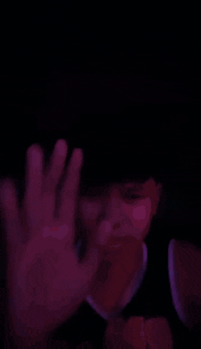 a close up of a person 's face in a dark room with their eyes closed .
