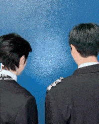 a man in a suit and tie is standing next to another man in a suit .