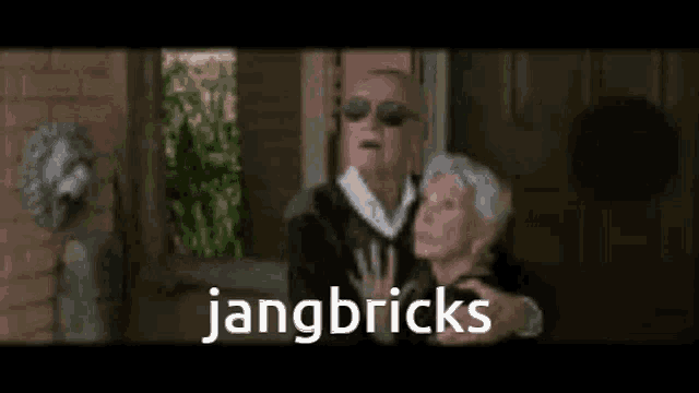 a man and a woman are standing next to each other and the words jangbricks are on the screen