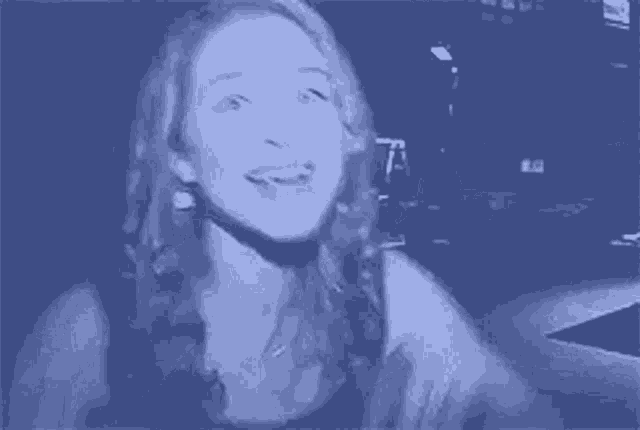 a woman is making a funny face and waving her hands in the air .