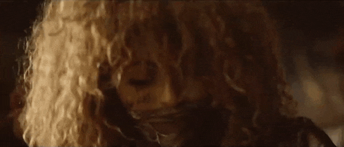 a woman is holding a flashlight in her hand and screaming .