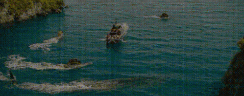 a boat is floating on top of a body of water next to a shark .