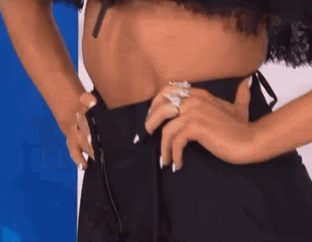 a close up of a woman 's stomach with her hands on her hips and a ring on her finger .