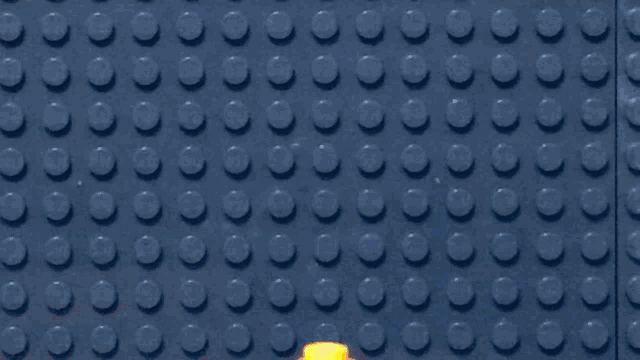a lego man in a red suit and tie with a red ribbon around his neck