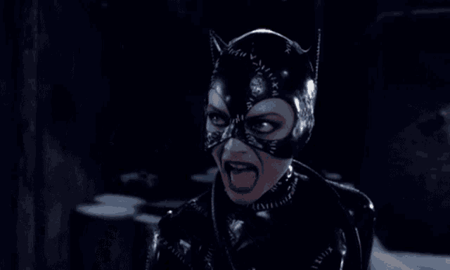 a woman in a catwoman costume is screaming with her mouth open
