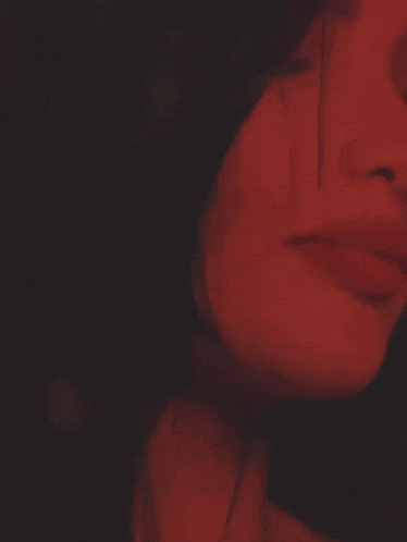a close up of a woman 's face with red lips and her eyes closed